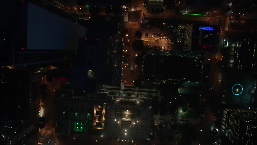 An aerial view of illuminated towering skyscrapers and buildings in downtown Los Angeles at night