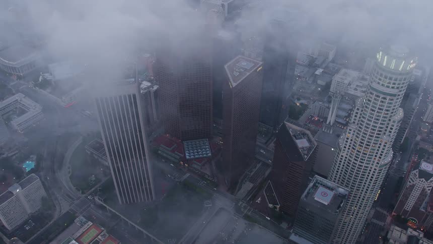 Aerial footage of downtown Los Angeles at twilight showcasing towering buildings obscured by wispy clouds shot in 4K by Sony CineAlta RAW
