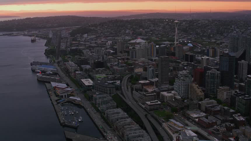An aerial shot of a major city on the waterfront at dusk