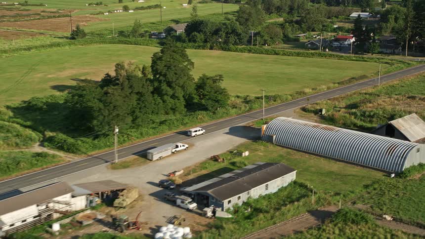 Aerial footage tracking a white van on a sunny day through farmland on a country road in Carnation Washington
