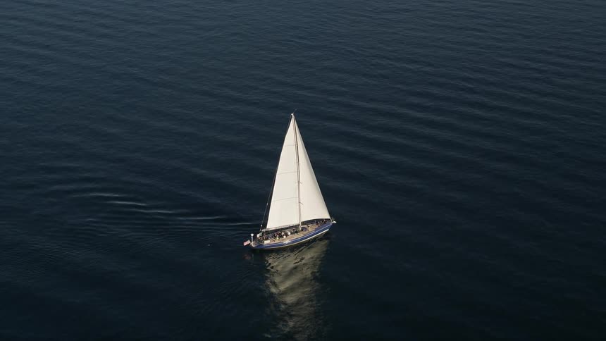 Aerial view of a sailboat gliding through Elliott Bay in Seattle Washington on a sunny day