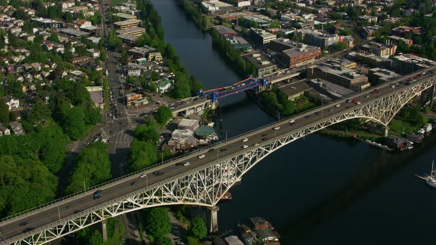 A large bridge spanning a waterway in a city during the day