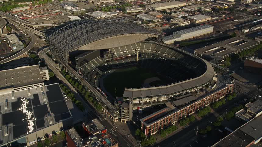 Aerial view of CenturyLink Field and Safeco Field in downtown Seattle Washington with a bustling metropolis and harbor in the background