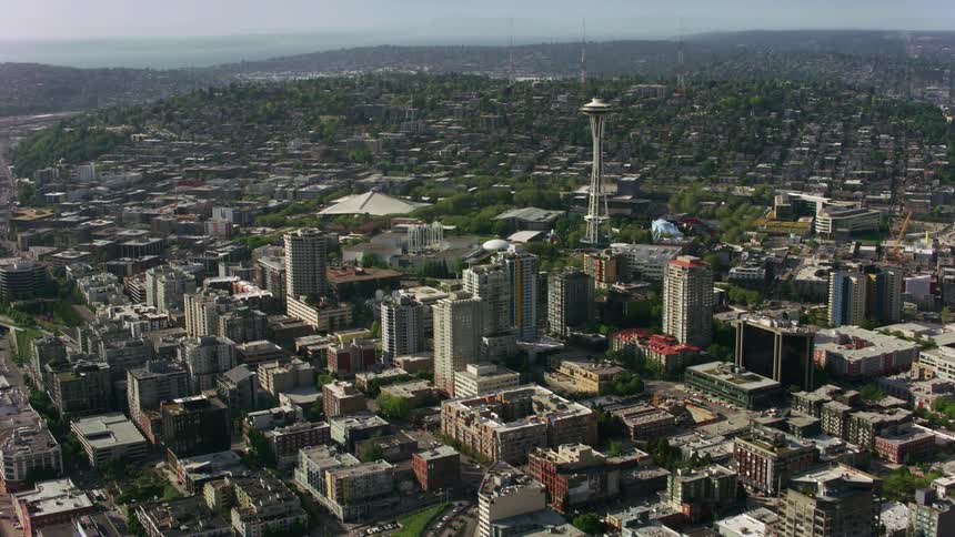 Traffic crosses through city with river near a space needle