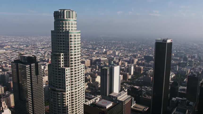 Flying between the US Bank Tower and Aon Center this 4K aerial footage showcases the sprawling cityscape of Downtown Los Angeles California