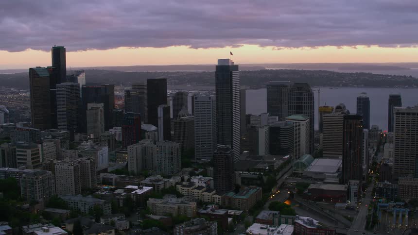 Aerial view of skyscrapers and high rise buildings near the sea at dusk