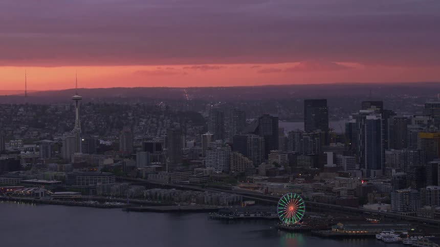 Aerial view of office buildings and skyscrapers near the sea at sunset
