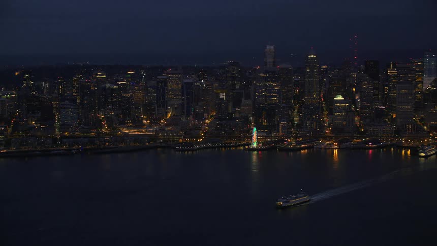 Ferry leaves wake while cruising away from city waterfront