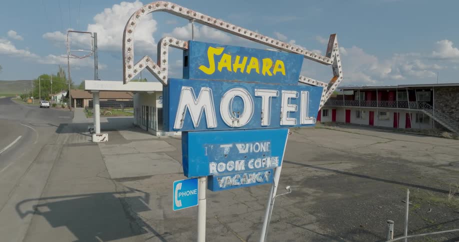 Pullback traverse out from an old motel roadside neon sign