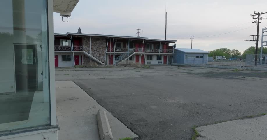 Gas pumps are ripped out of an old service station and gift shop in front of an abandoned motel