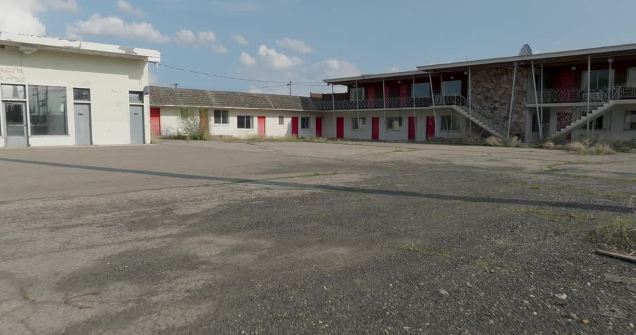Flying through the broken chain link fence of an abandoned old motel