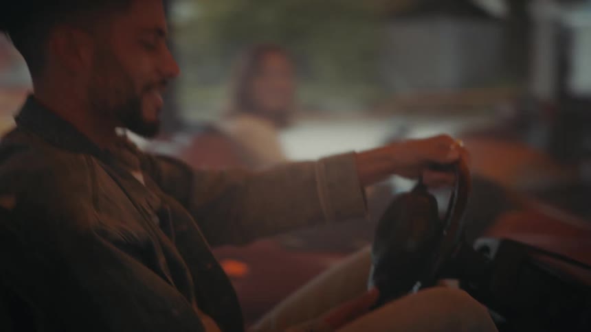 A man smiling while driving a bumper car