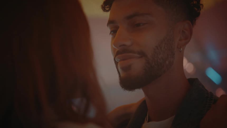 A man and a woman smile at each other while dancing together