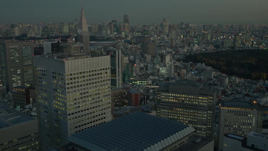 Panoramic view of illuminated apartment buildings public park and city skyline at dusk