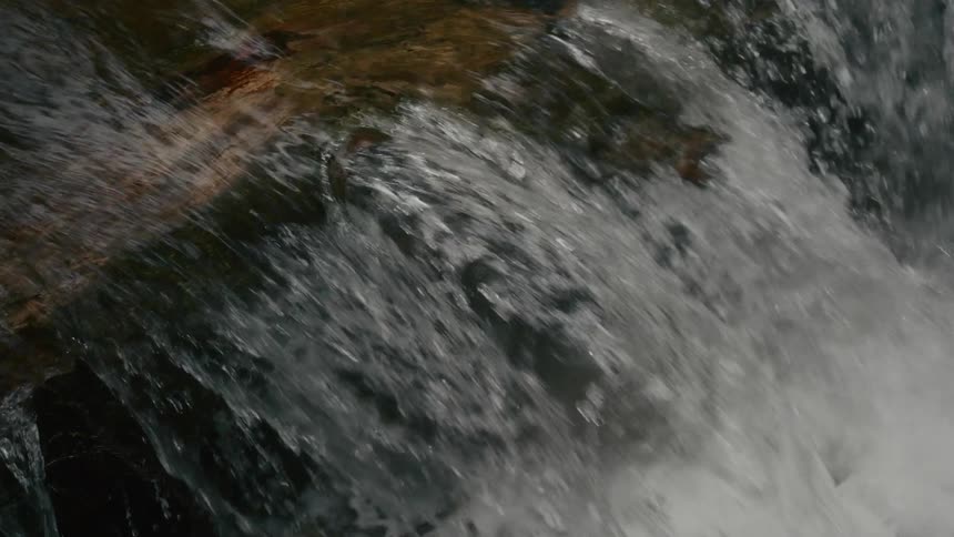 A waterfall flows down the side of a cliff