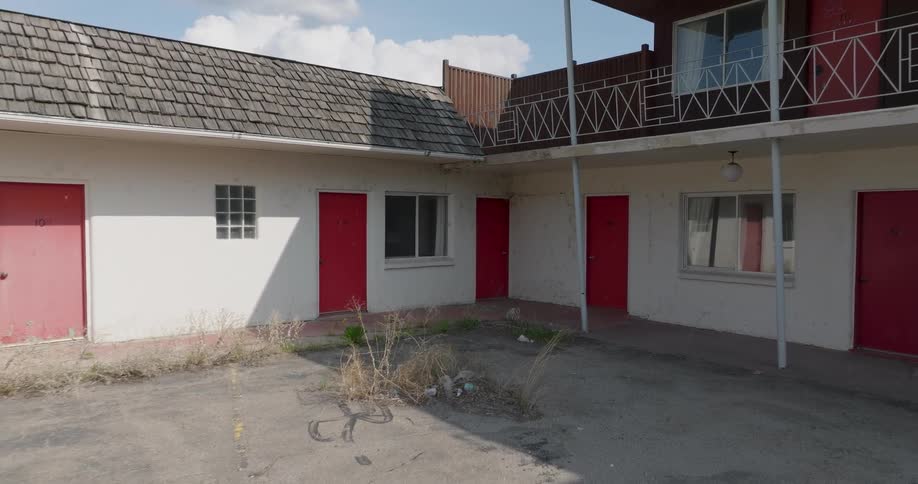 Vacant rooms sit behind the red doors of a dilapidated motel