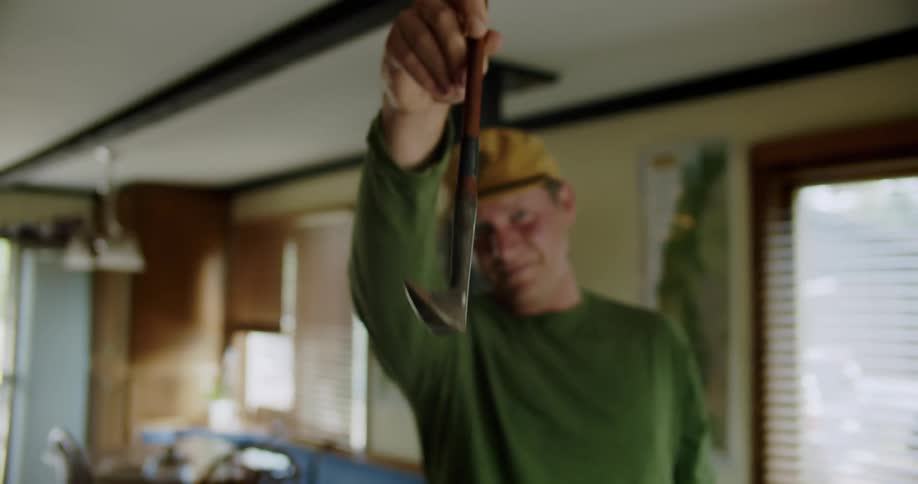 Man stands at home and smiles while examining golf club
