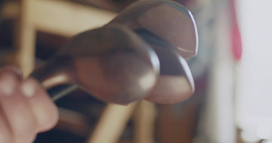 A man holds metalheaded golf clubs sentimentally