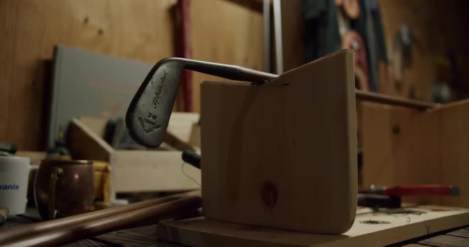 Golf club leans on wooden frame in workshop