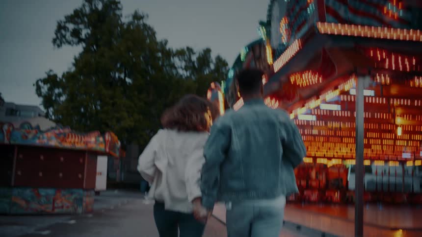 A couple run in the amusement park