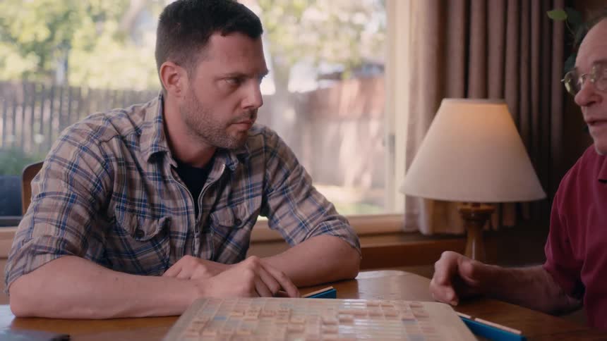 Two men are playing scrabble