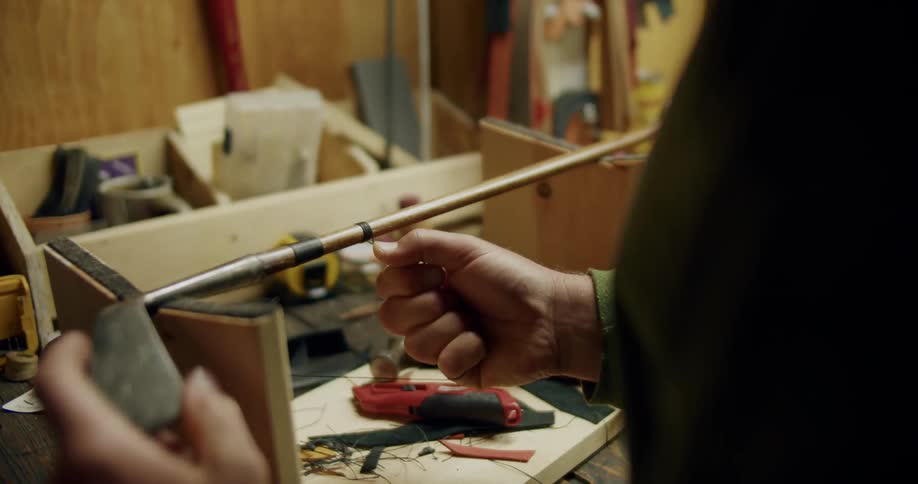 A person is wrapping their golf club