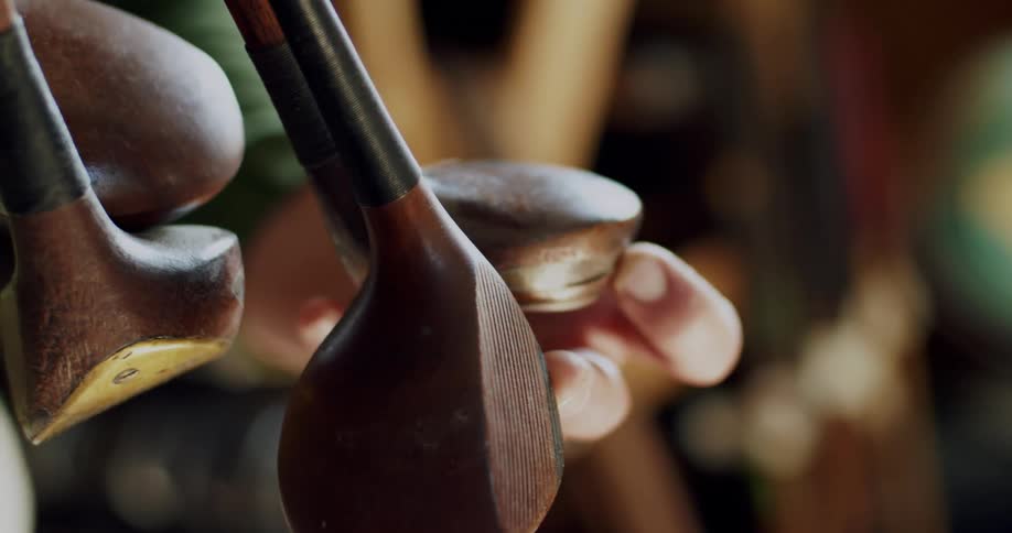 A man holds onto golf clubs