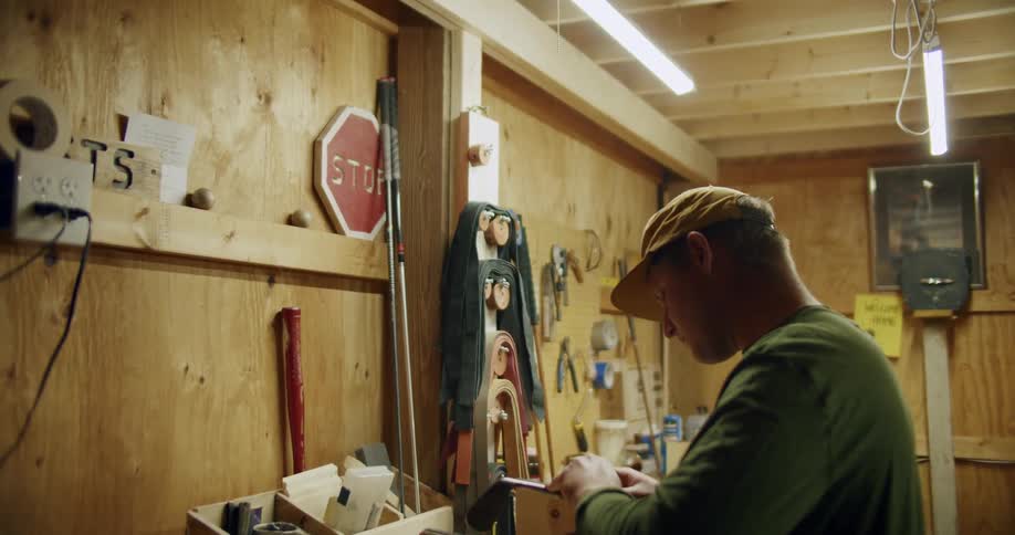 A man fixes a golf club in his workshop