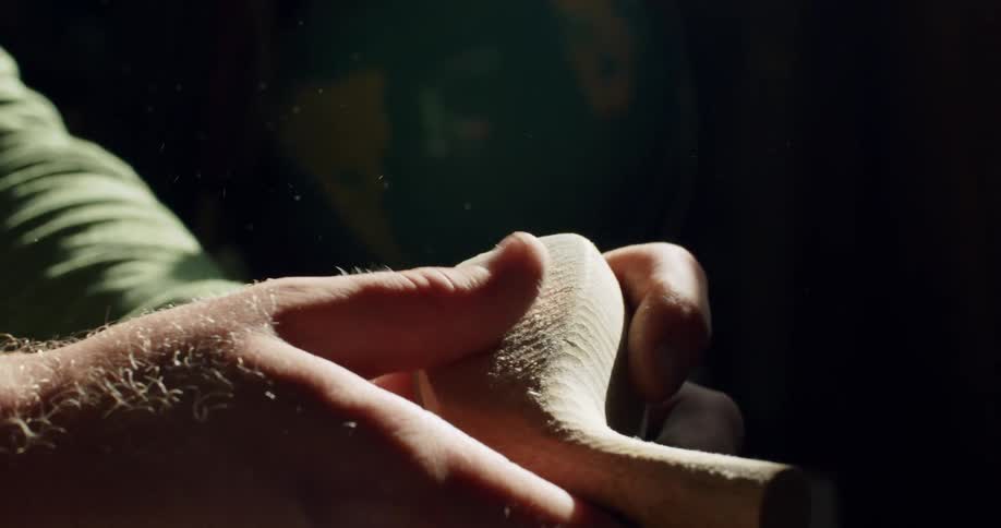 A mans hands feel and examine a freshly carved wooden head of a golf club