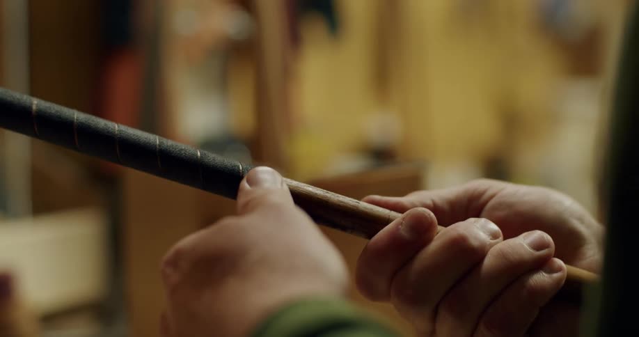 Male hands applying tape to the grip of a golf club