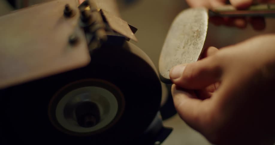 Person grinds head of golf club creating sparks