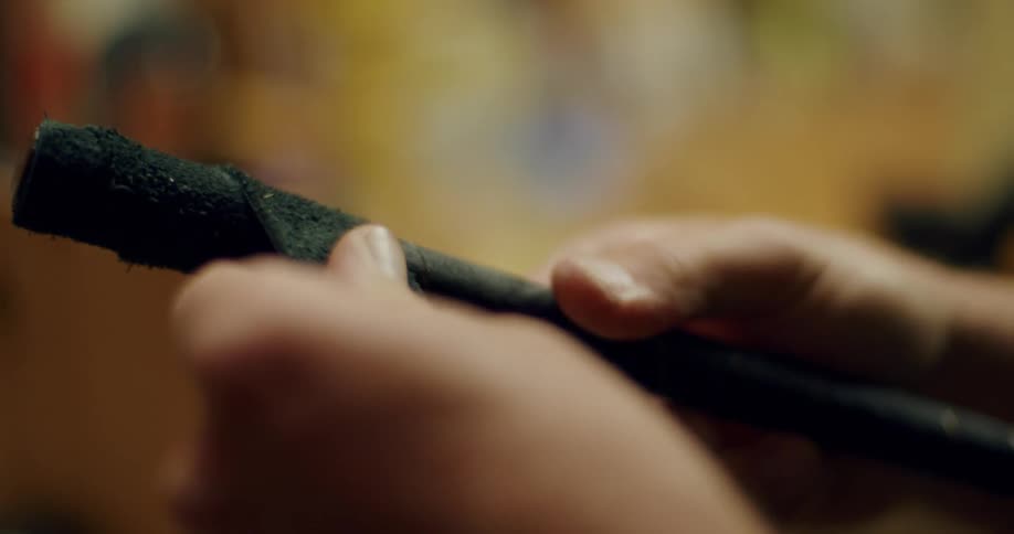 A man wraps black tape around a thin bar