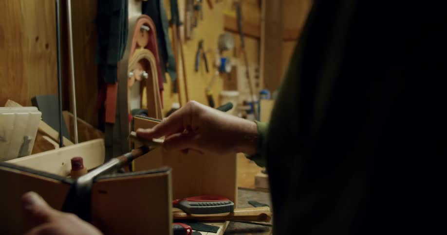 A man files down the sides of a golf putter