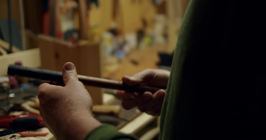 Male human hands applying tape to the grip of a golf club