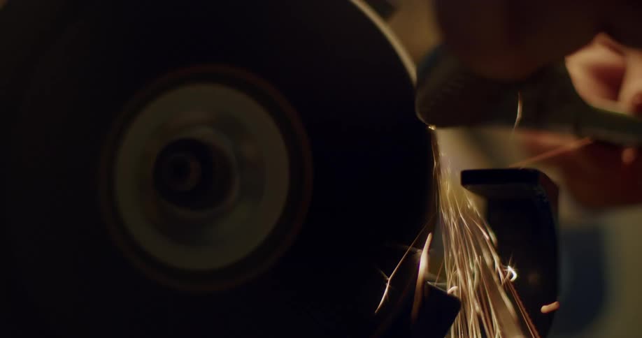 A person using a grinder on a piece of metal
