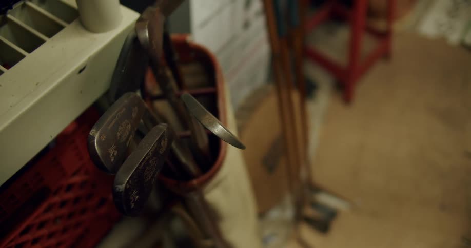 A bag of golf clubs is leaning against the shelf