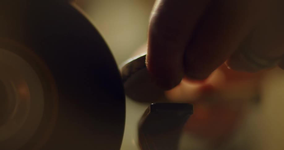 A close up of a person using a grind stone creating sparks