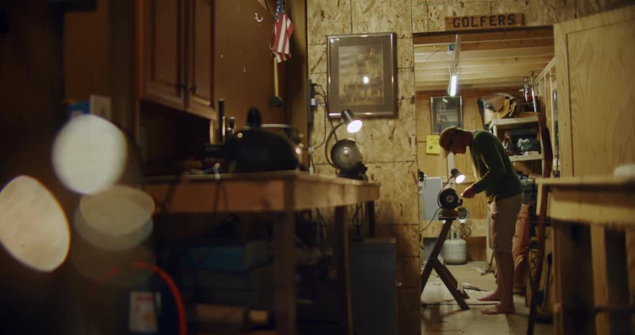 A man is using a machine in his workshop