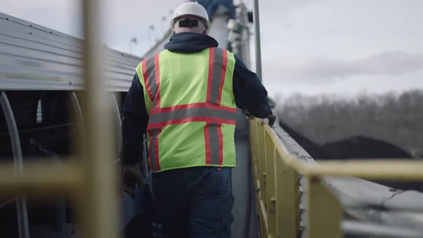 Workers walk along the railing of a bridge