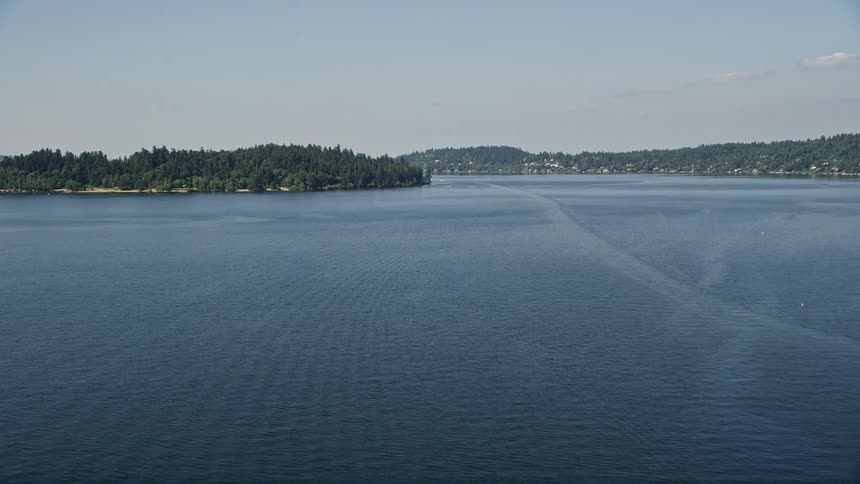 Aerial view of Lake Washington and Mercer Island Washington on a sunny day approaching the shoreline with beautiful nature scenery