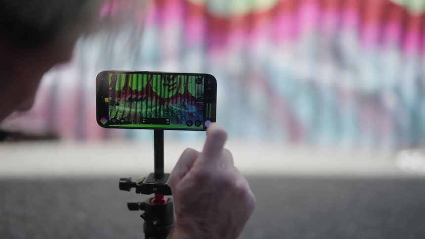 Man films graffiti wall with smartphone