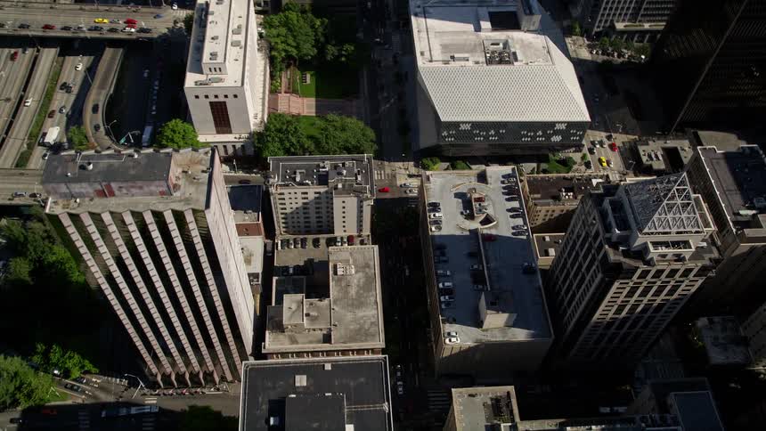 Aerial view of Downtown Seattle tilting down to reveal intersection beside the Seattle Public Library