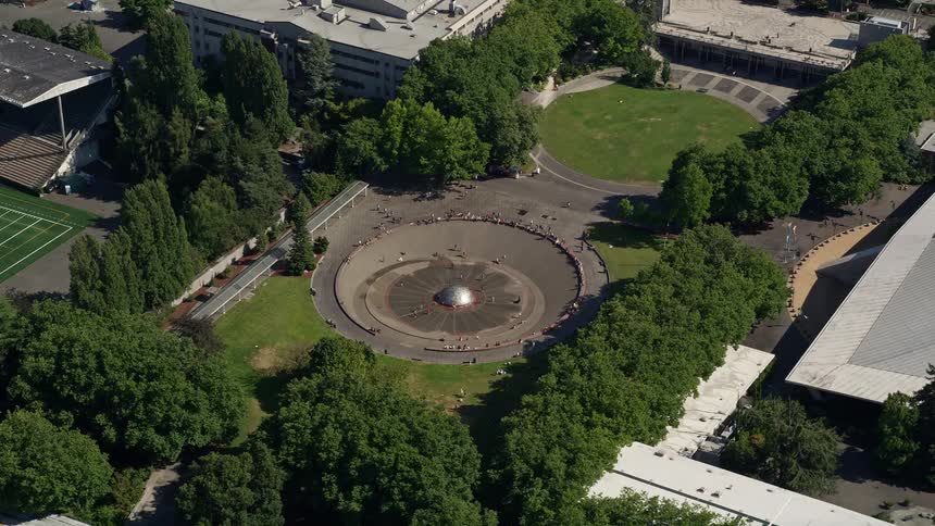 Aerial footage of the Seattle Center Fountain in Downtown Seattle Washington surrounded by a bustling metropolis in the sunshine