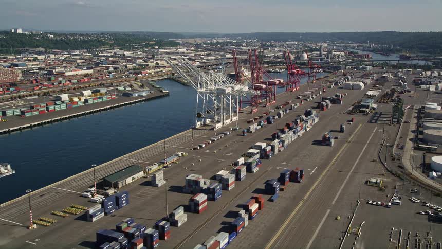 Aerial footage of cargo cranes and rows of shipping containers at Harbor Island Seattle Washington showcasing the bustling shipping industry and industrial waterfront