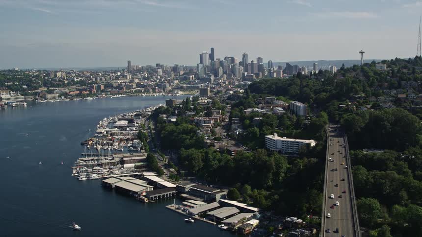 An awe-inspiring aerial view of cars crossing Aurora Bridge boats at the harbors and the distant city skyline of Downtown Seattle on a sunny day in Washington