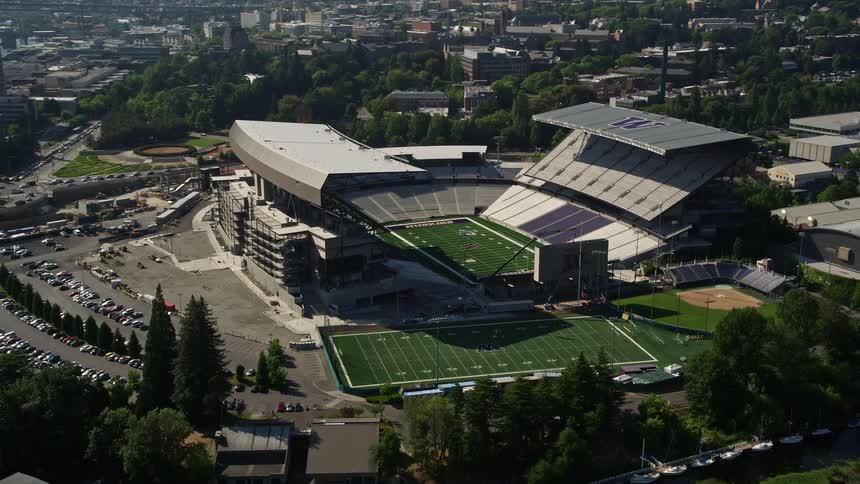 Aerial footage showcasing Husky Stadium and the city skyline in Seattle Washington during a sunny day highlighting the university's athletic and educational activities as well as the surrounding recreational opportunities