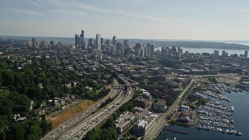  aerial footage showing heavy traffic on Interstate 5 approaching the downtown Seattle skyline on a sunny day