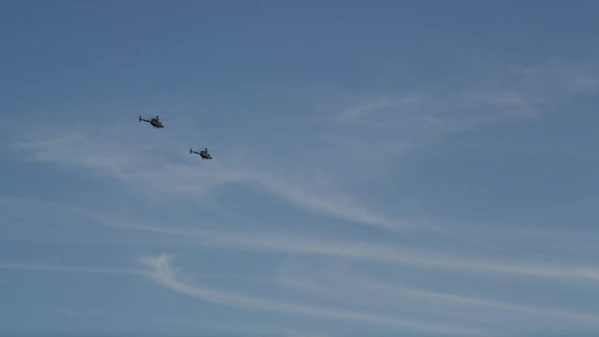 Two Kiowa Warrior helicopters are tracked as they fly over Downtown Seattle on a sunny day