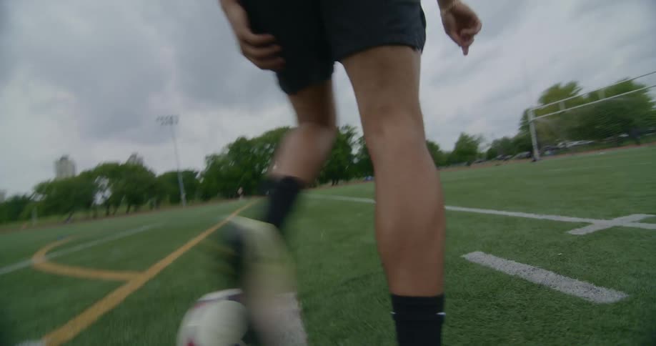 A man kicks around a soccer ball on the field