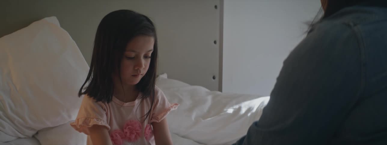 A girl is talking to a woman in bed